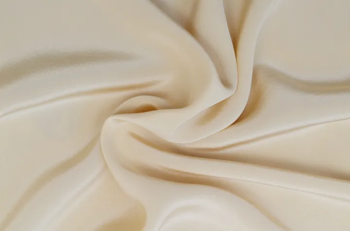 Beige silk fabric in close-up, as described by the image source